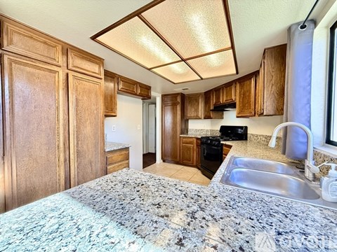 A kitchen with a sink and a bed.
