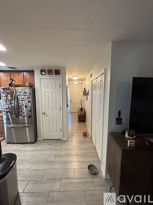 A kitchen with a fridge, a door, and a counter.