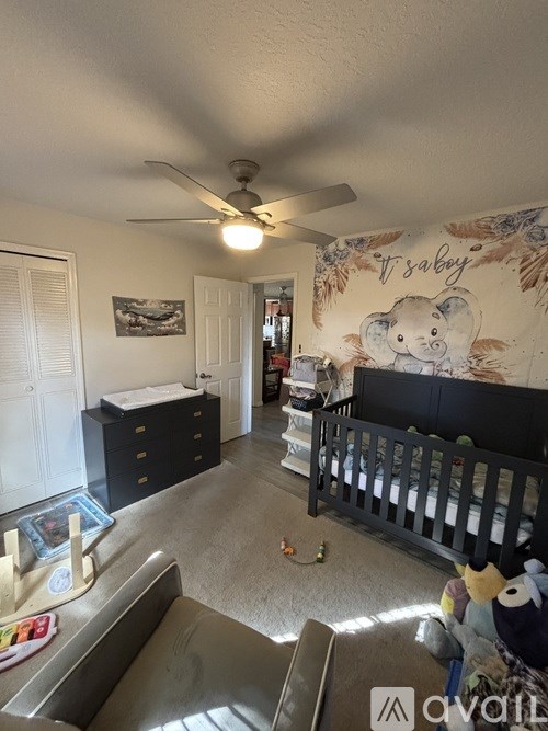 A baby room with a crib and a wall mural of a bear.