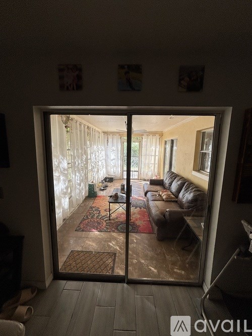 A living room with a couch and a rug is visible through an open door.