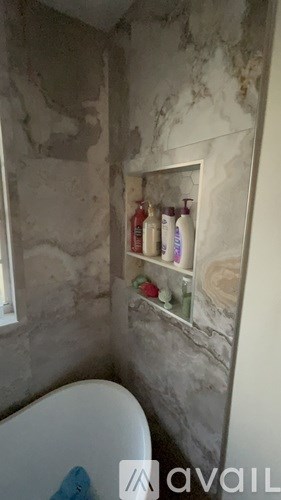 A bathroom with a marble wall and a white toilet.