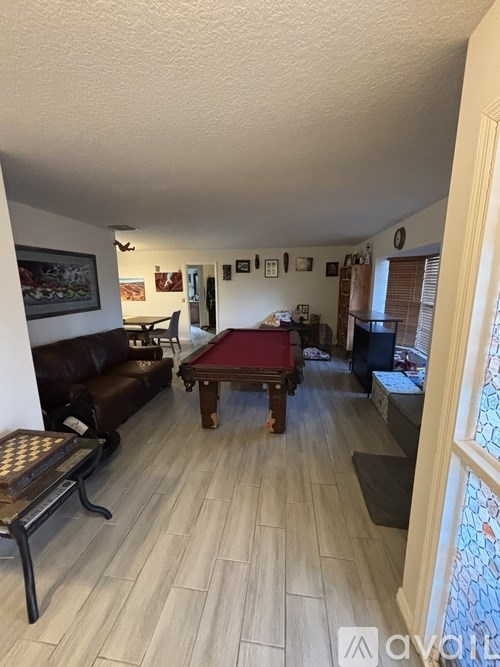 A living room with a pool table and a couch.