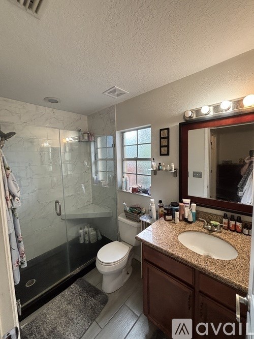 A bathroom with a marble shower and a sink.