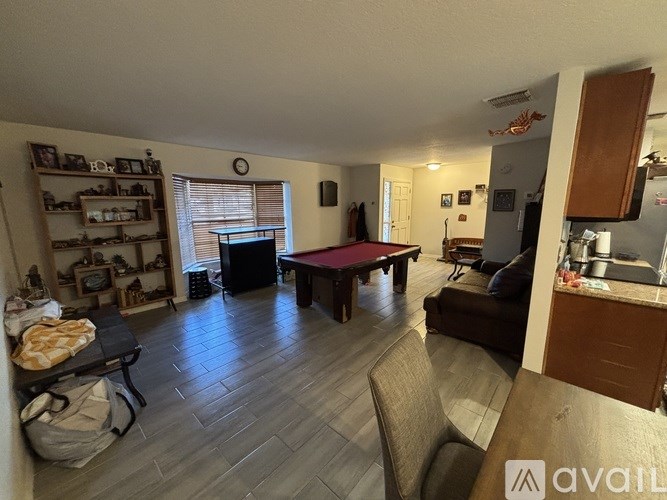 A living room with a pool table and a couch.