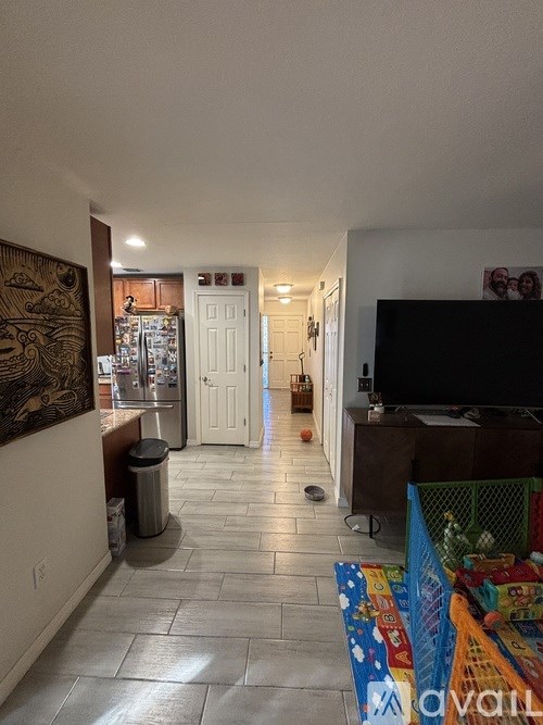 A living room with a television and a doorway leading to another room.