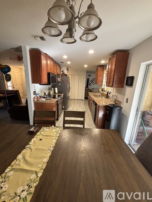 A kitchen with wooden cabinets and a dining table with a floral runner.