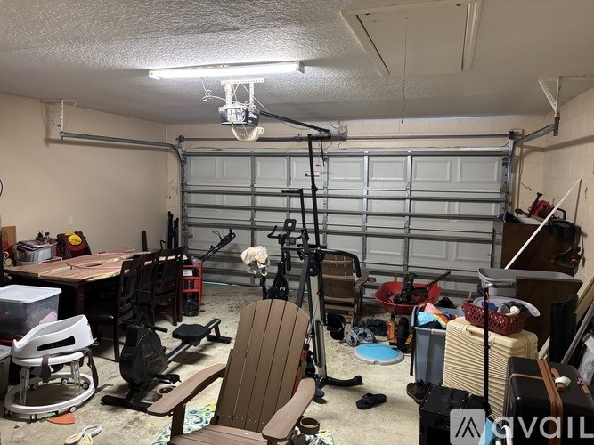 A garage with a lot of clutter and a chair in the foreground.
