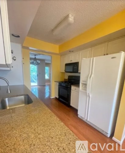A kitchen with a white refrigerator and a sink.