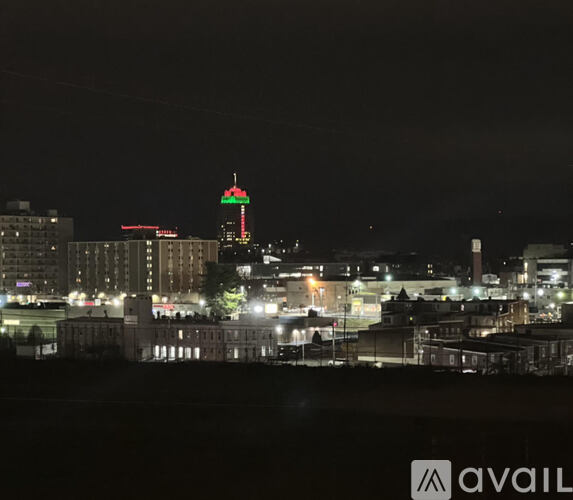 A cityscape at night with a prominent building in the center.