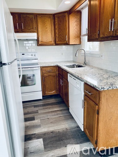 A kitchen with wooden cabinets and a white fridge.