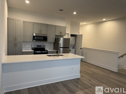 A modern kitchen with white cabinets and a white countertop.