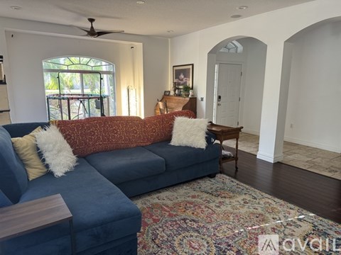 A living room with a blue couch and a rug.