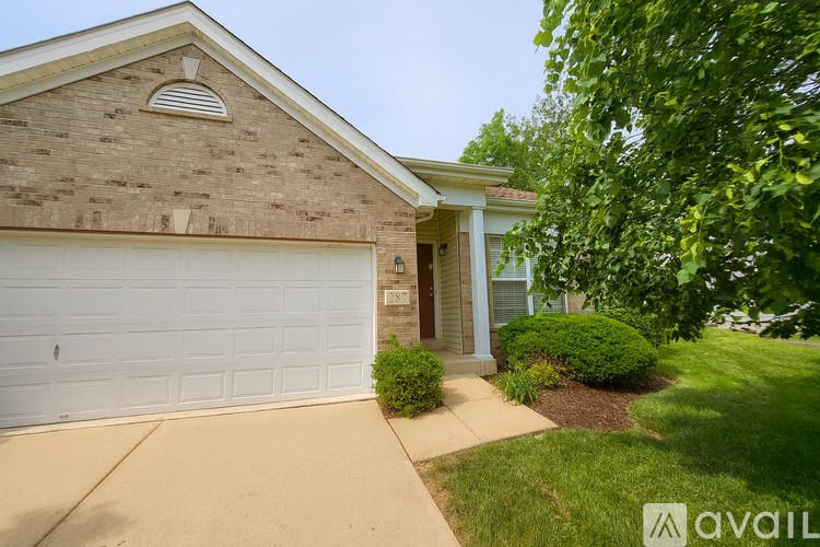 A house with a white garage door and a brick wall.