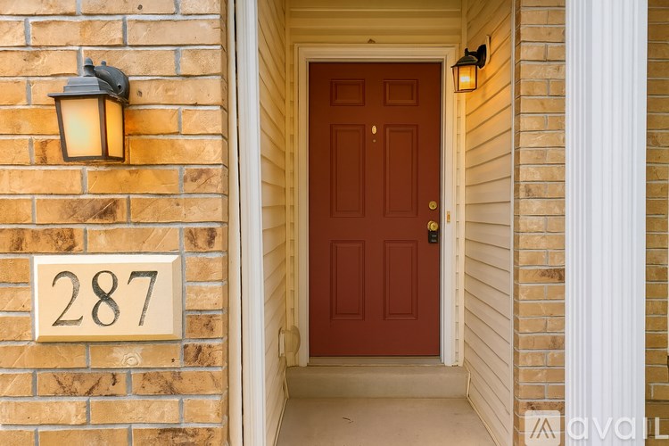 A brown door is at the end of a hallway.