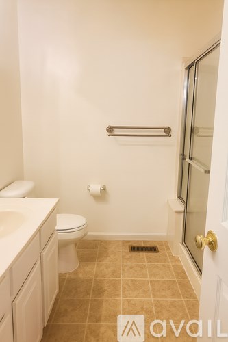 A bathroom with a toilet, sink, and a towel bar.