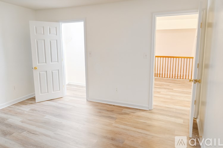 A room with a white door and a balcony with orange railings.