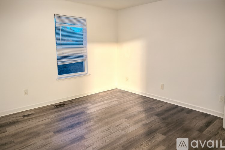 A room with a window and wooden flooring.
