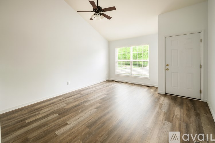 A room with a ceiling fan and wooden flooring.