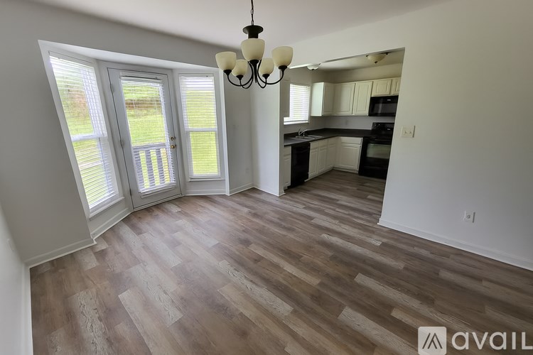 A room with wooden flooring and a chandelier hanging from the ceiling.