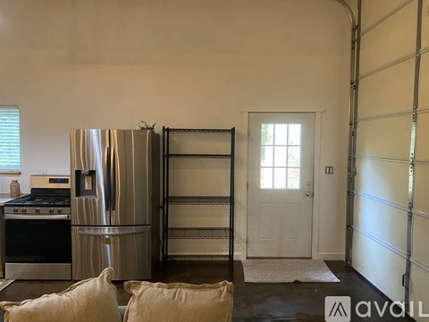 A kitchen with a stainless steel refrigerator and a black stove top oven.