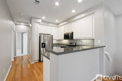 A kitchen with white cabinets and a granite countertop.