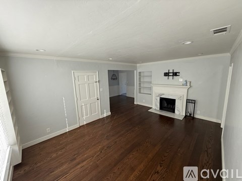 A living room with a fireplace and a television on the wall.