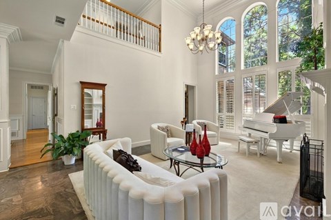 A living room with a white sofa and a chandelier.
