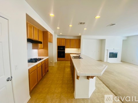 A kitchen with wooden cabinets and a white island.