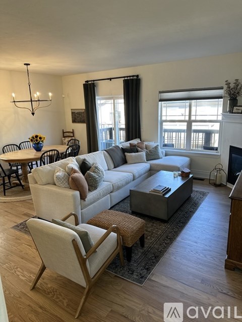 A living room with a white couch, a coffee table, and a dining table with chairs.