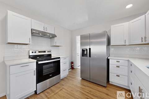 A modern kitchen with white cabinets and stainless steel appliances.