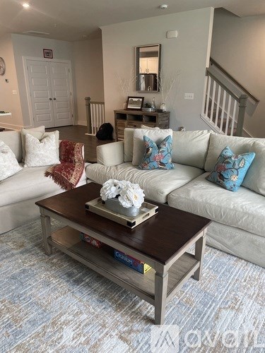 A living room with a white couch and a coffee table in the center.