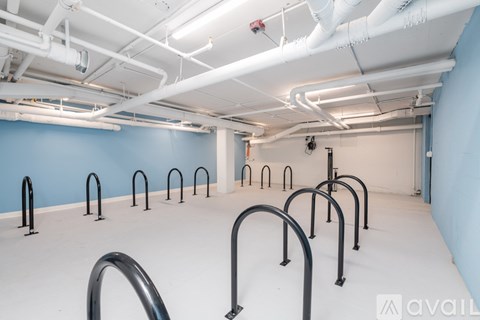 A gym with a blue wall and white ceiling with pipes.