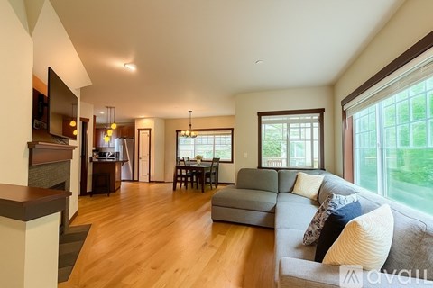 A living room with a grey couch and a wooden floor.