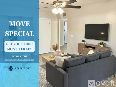 A living room with a grey sofa and a black television mounted on the wall.