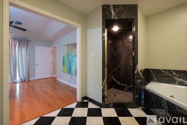 A bathroom with a marble tub and a checkered floor.