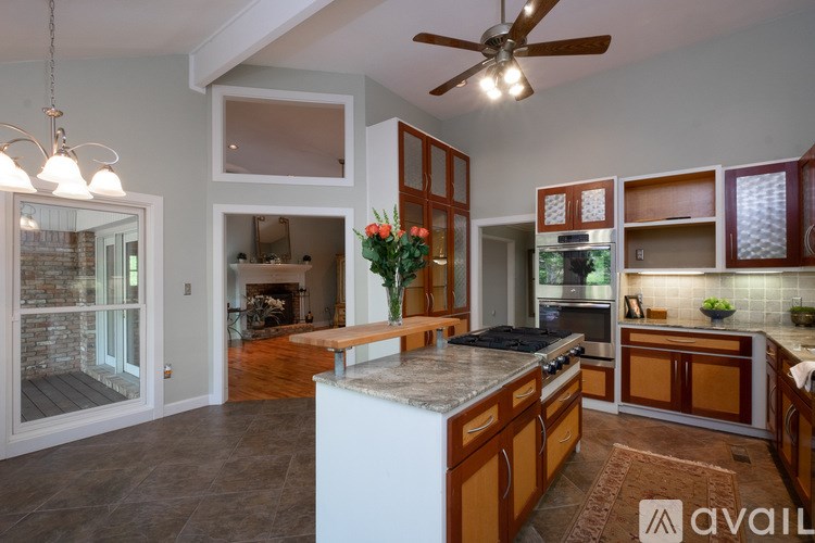 A kitchen with a large island and wooden cabinets.