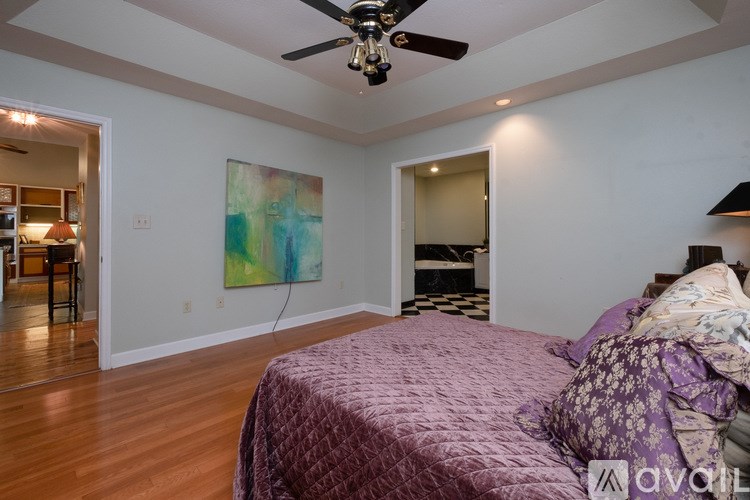 A bedroom with a bed and a ceiling fan.
