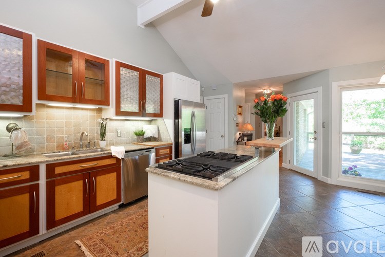 A kitchen with brown cabinets and a white island.