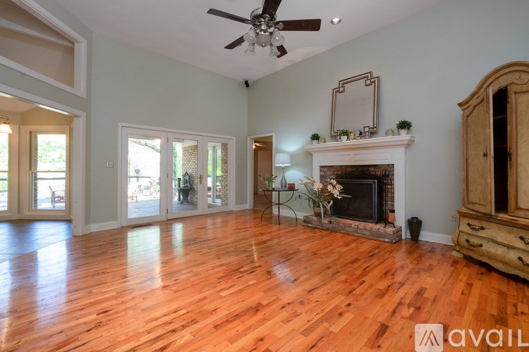 A spacious room with a fireplace and wooden floors.