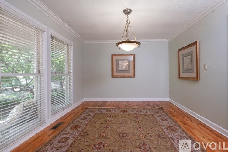 A room with a rug on the floor and a picture on the wall.