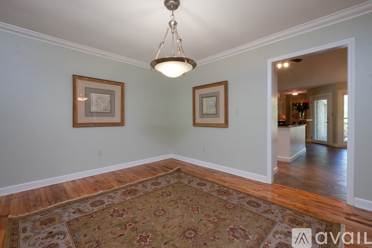 A room with a rug on the floor and two pictures on the wall.
