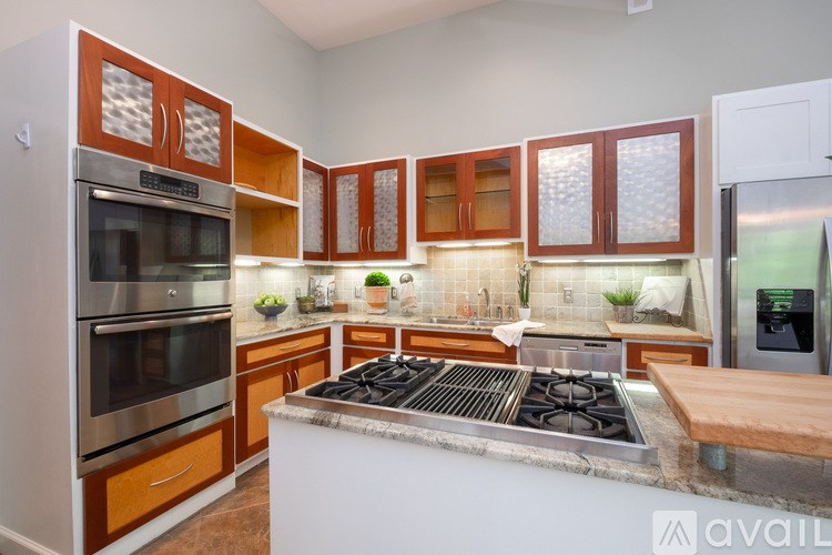 A kitchen with wooden cabinets and a stainless steel stove top.