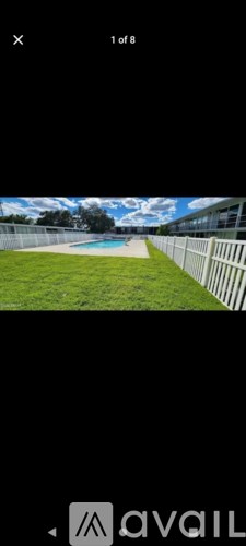 A view of a pool surrounded by a white fence.