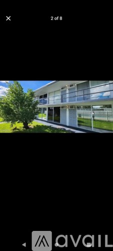 A modern house with a balcony and a tree in front.