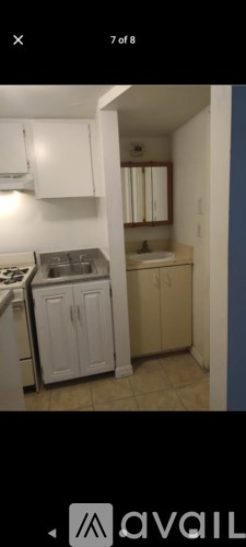 A kitchen with white cabinets and a stainless steel sink.