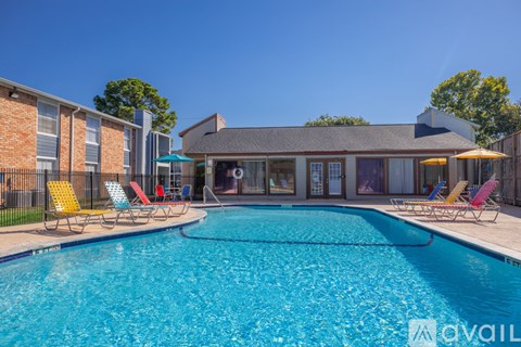 A pool with chairs around it and a house in the background.