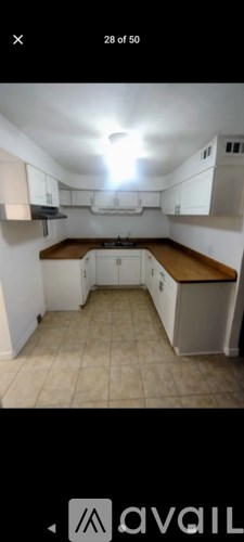 A kitchen with white cabinets and a wooden countertop.