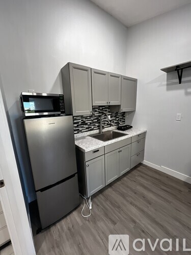 A kitchen with a stainless steel refrigerator and microwave.