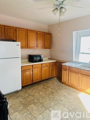 A kitchen with wooden cabinets and a white refrigerator.