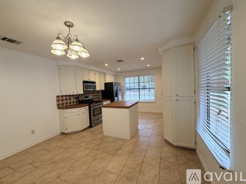 A kitchen with white cabinets and a tiled backsplash.